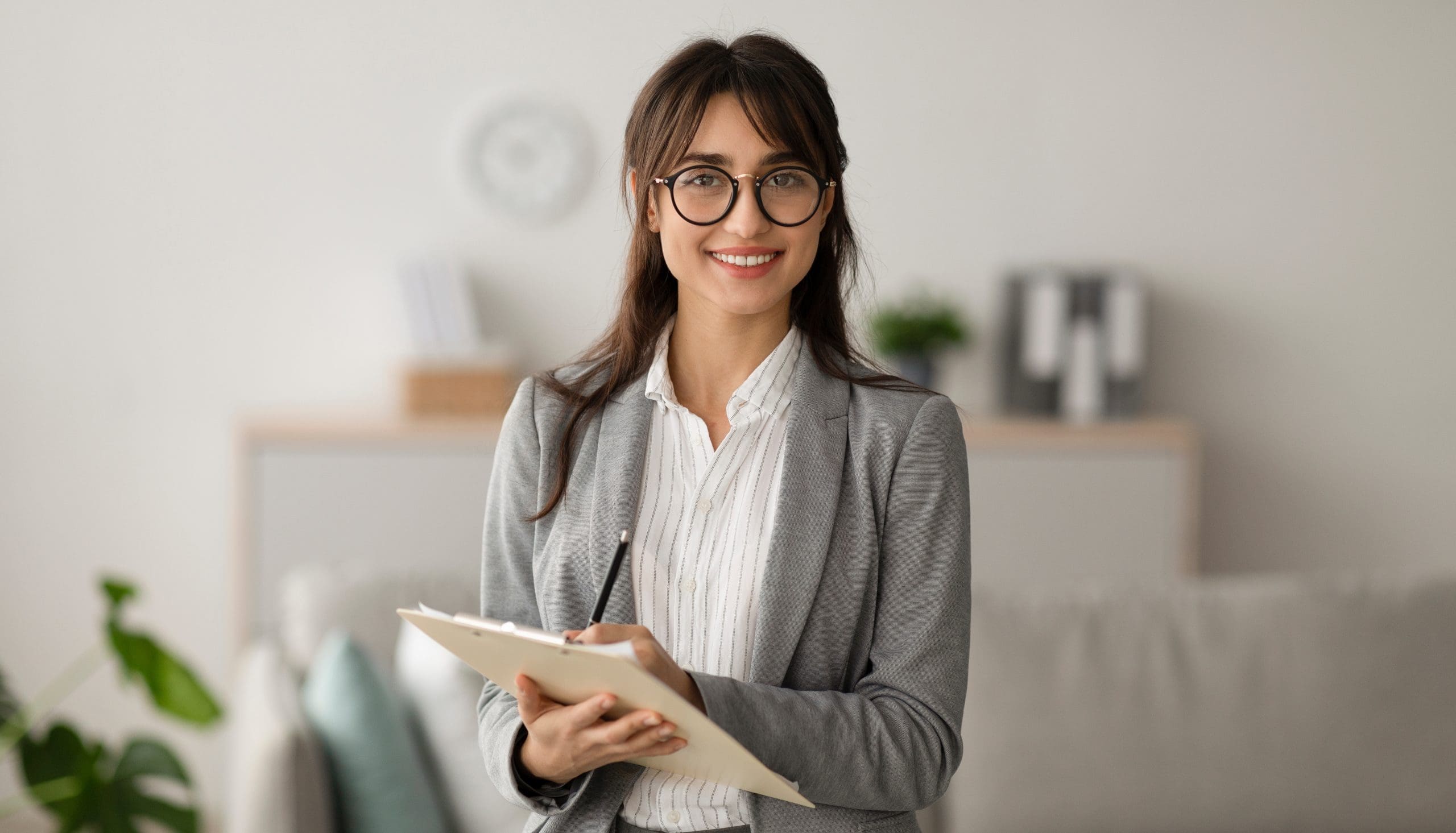 Happy,Professional,Middle,Eastern,Female,Psychologist,Writing,In,Clipboard,,Looking - The Link Center Professional woman holding pencil and notepad